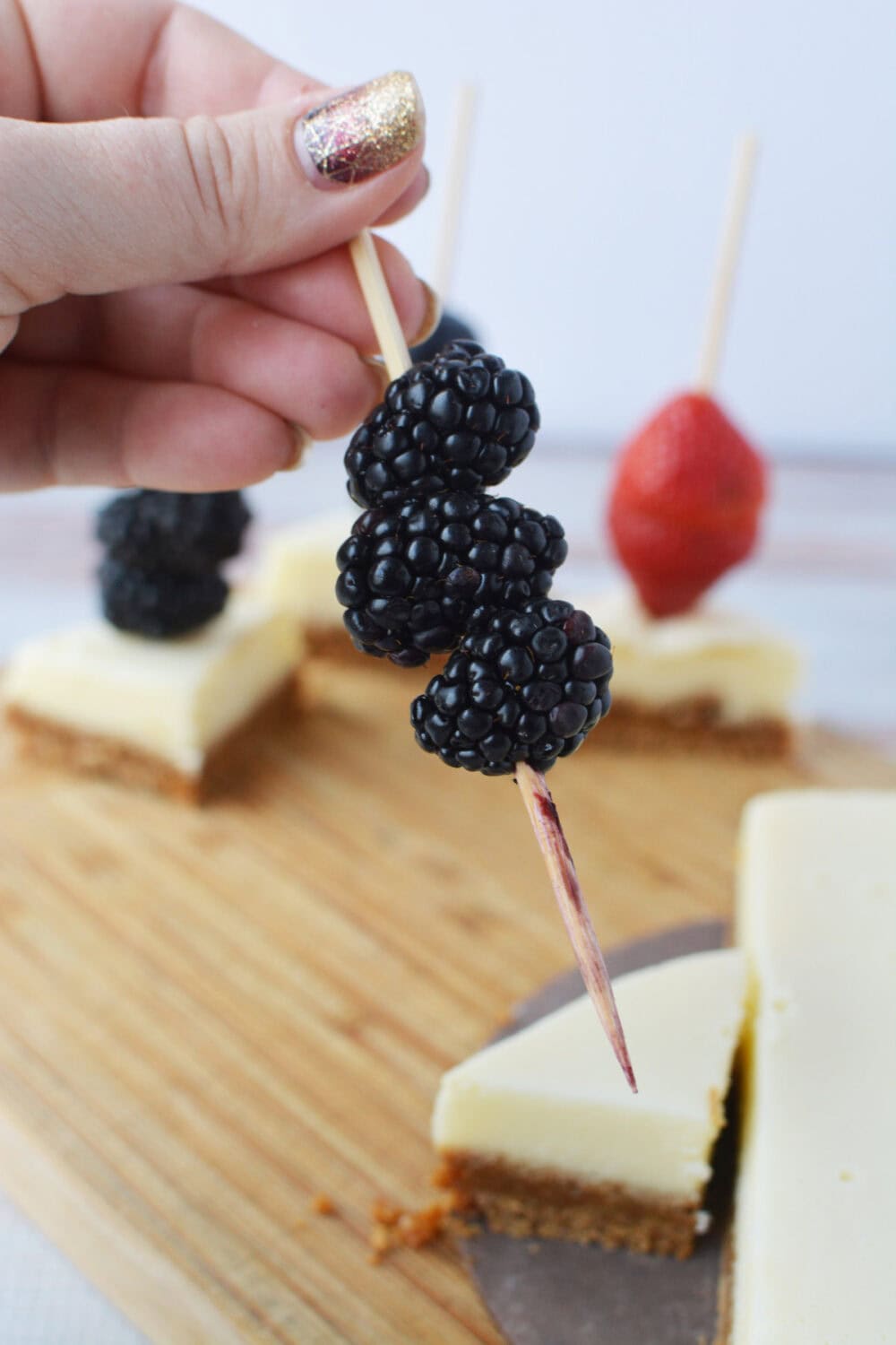 Adding blackberries to a skewer.