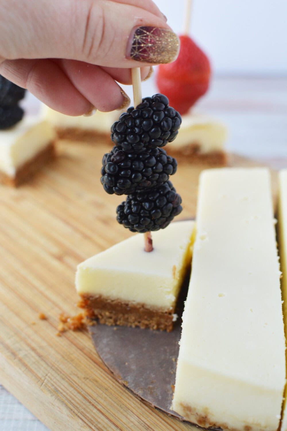 Skewering blackberries with cheesecake. 