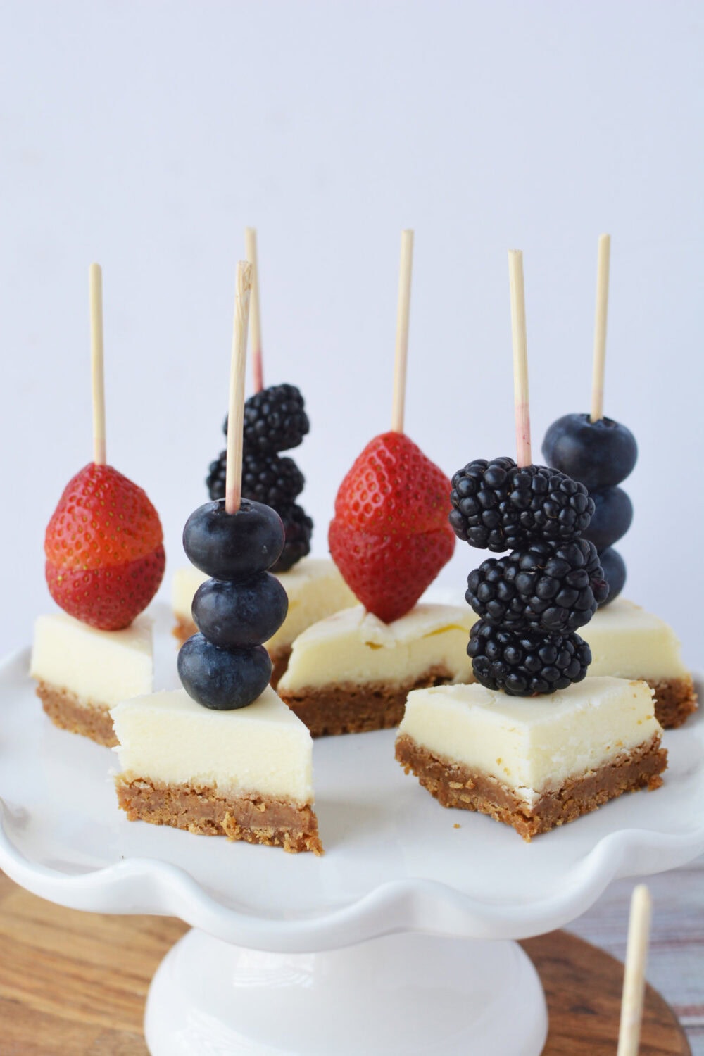 Serving platter of cheesecake bites with berries.