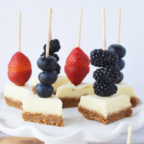 Cheesecake skewers on a serving platter.