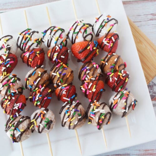 A try full of donut hole skewers.