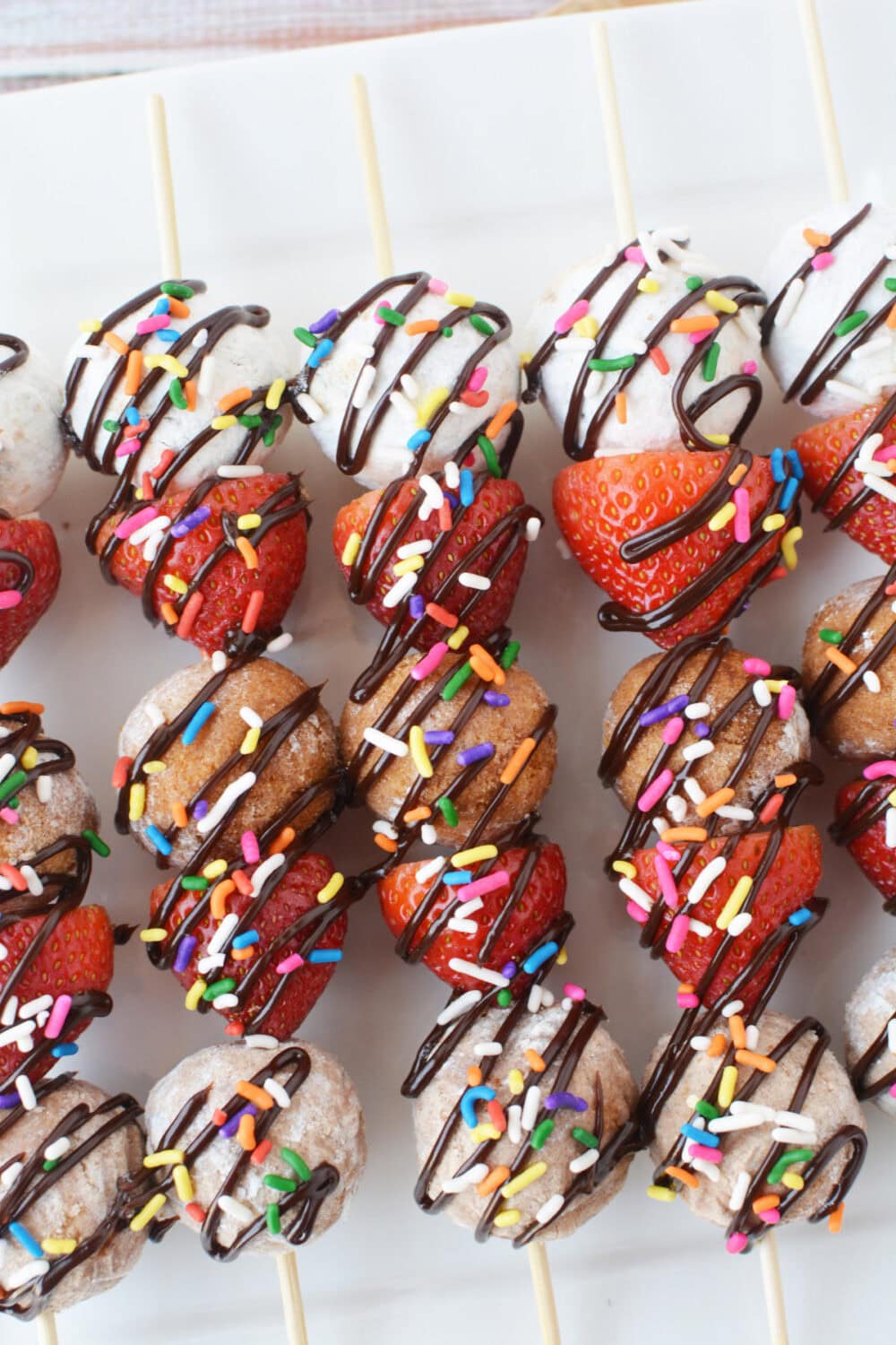 Donut hole dessert kabobs on a tray.