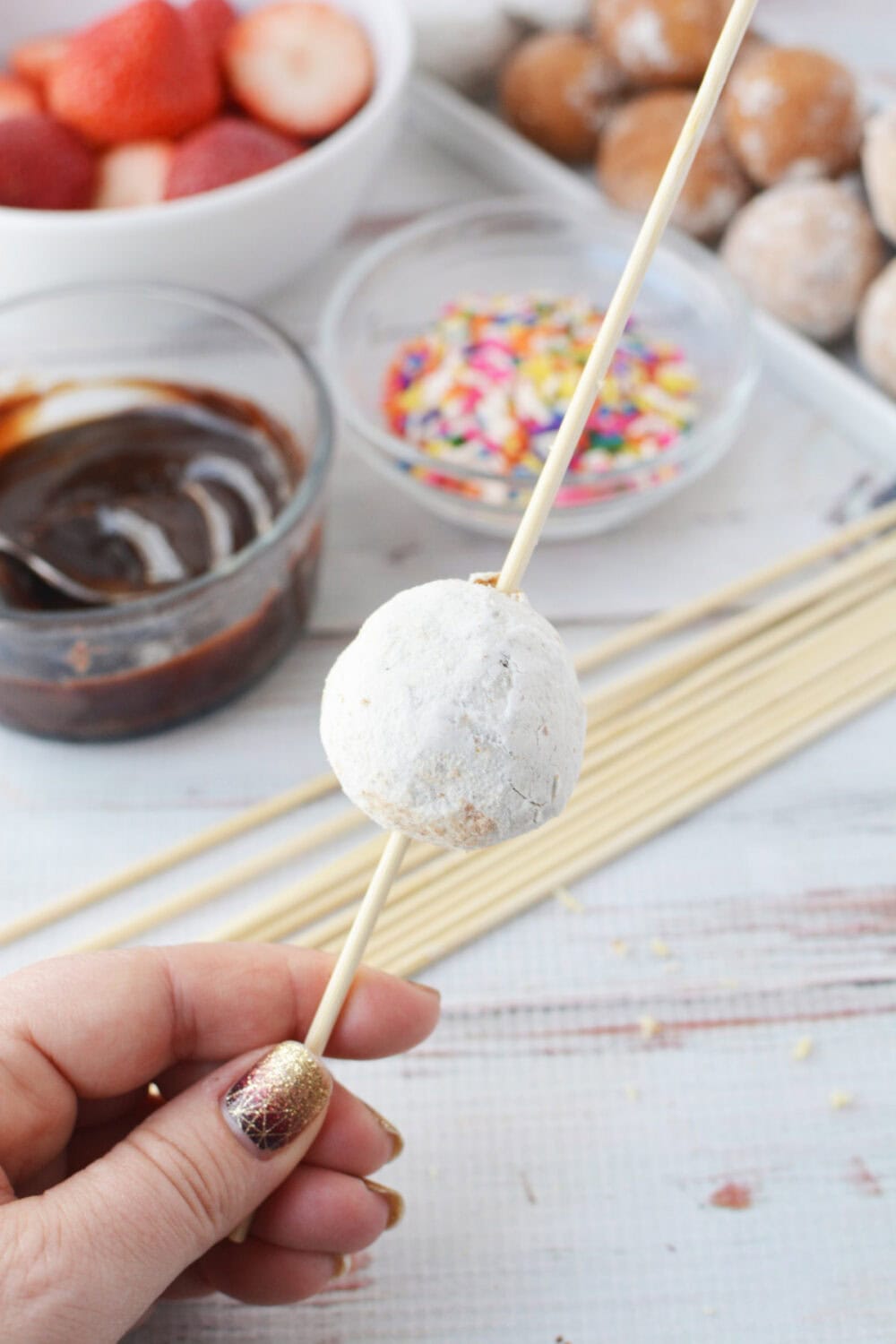 Powdered donut hole on a skewer.