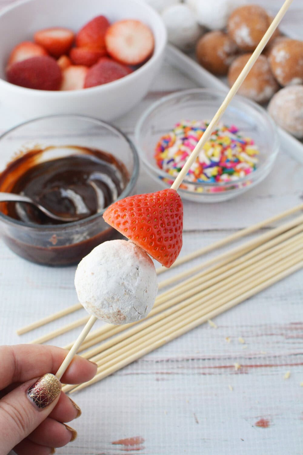 Strawberry and donut hole on a skewer.