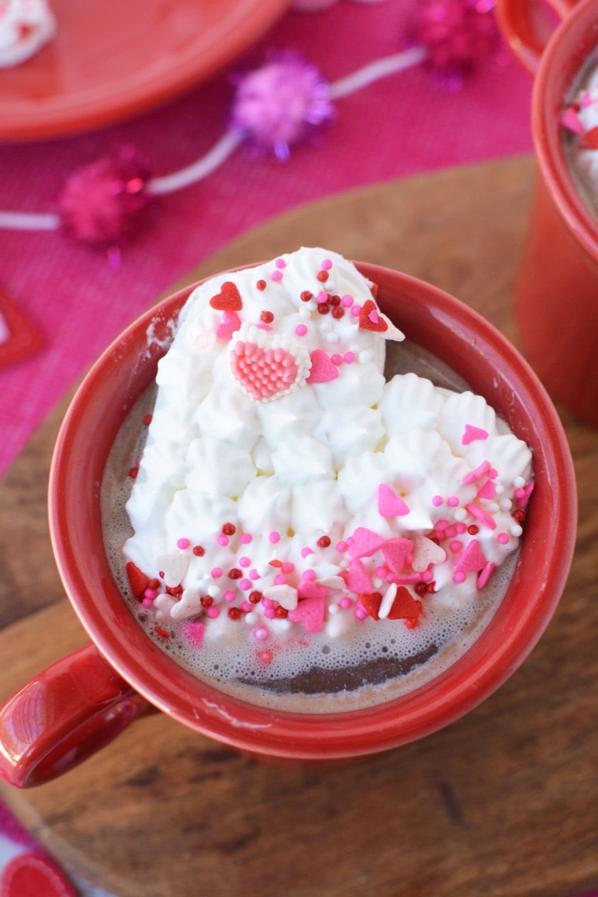 Heart-shaped whipped cream on top of a mug of hot chocolate.