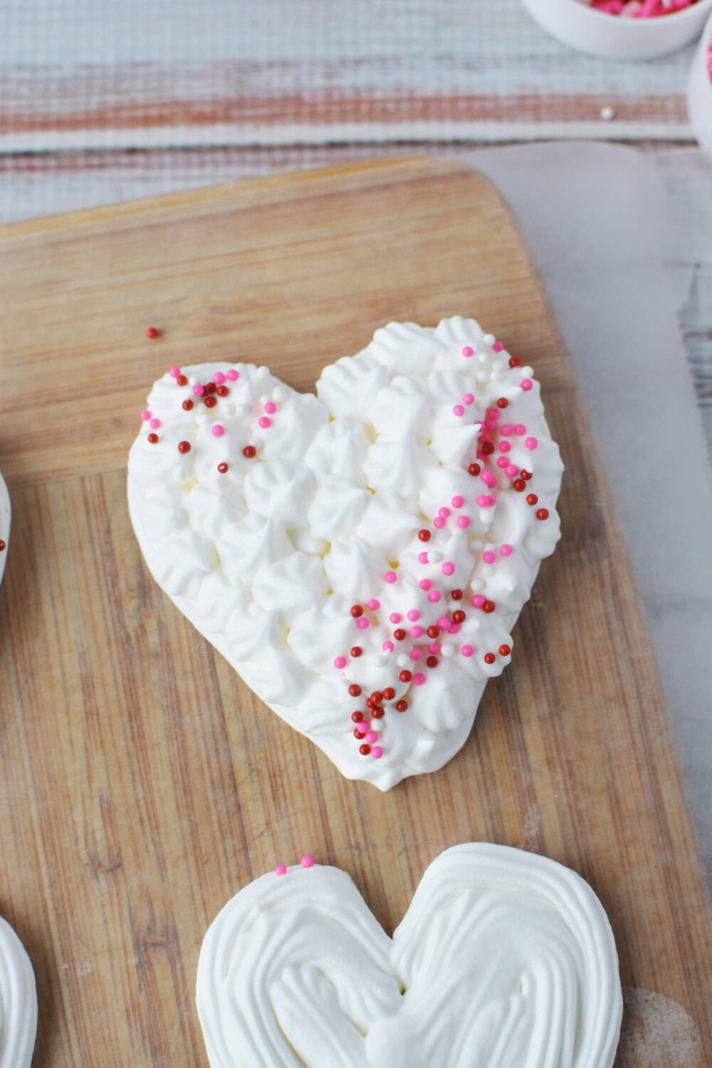 Sprinkles onto heart-shaped whipped cream. 