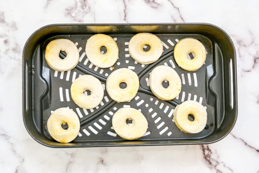 Biscuit donuts in an air fryer basket.