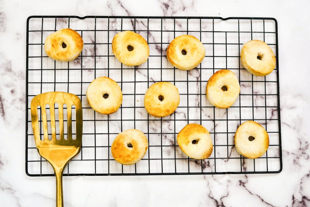 Golden brown donuts on a wire rack.