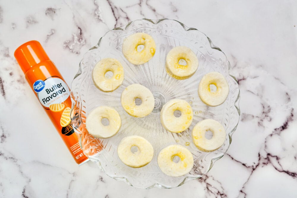 Biscuit donuts sprayed with cooking spray.