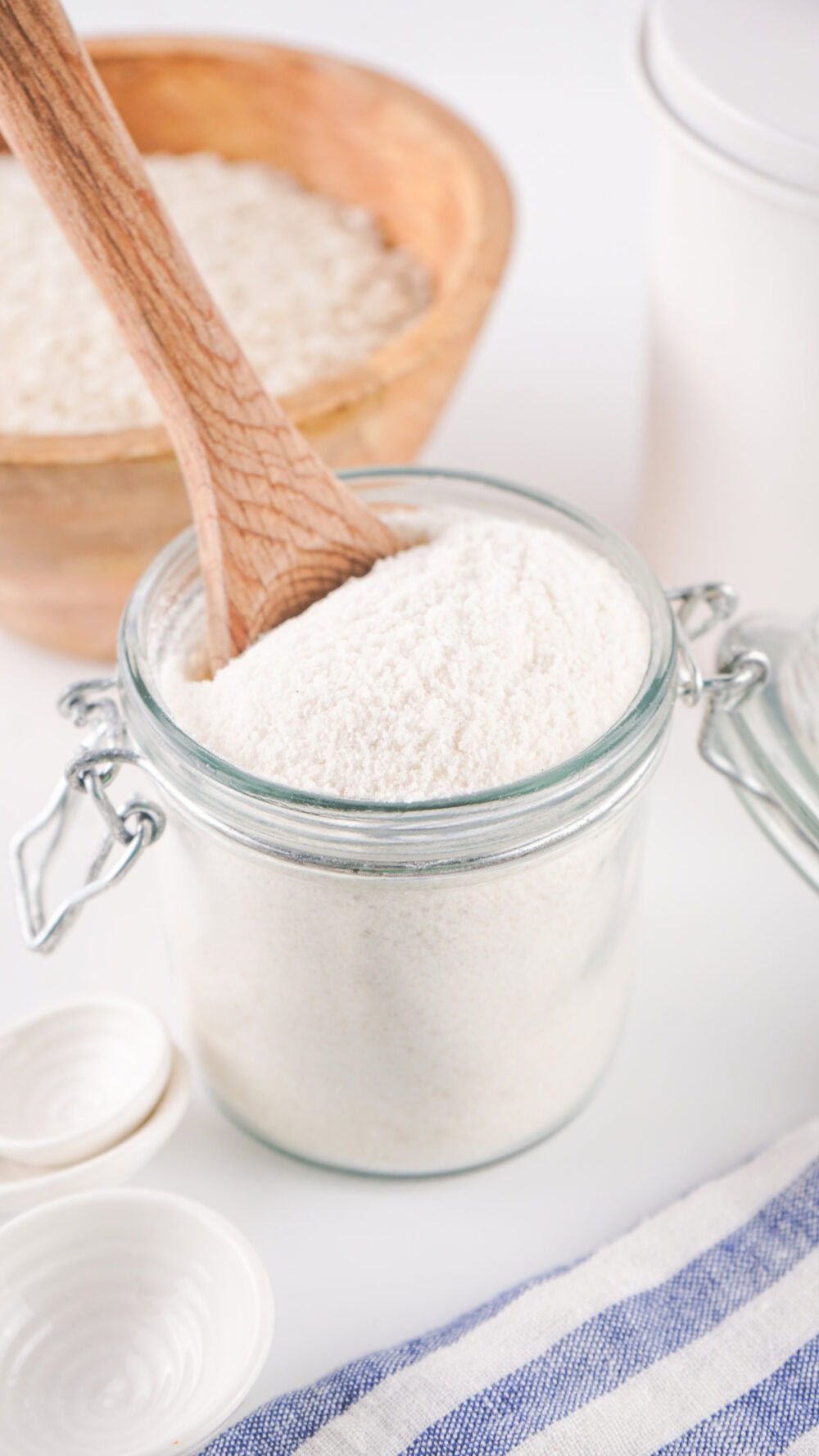 Spoon in rice flour in a glass container.