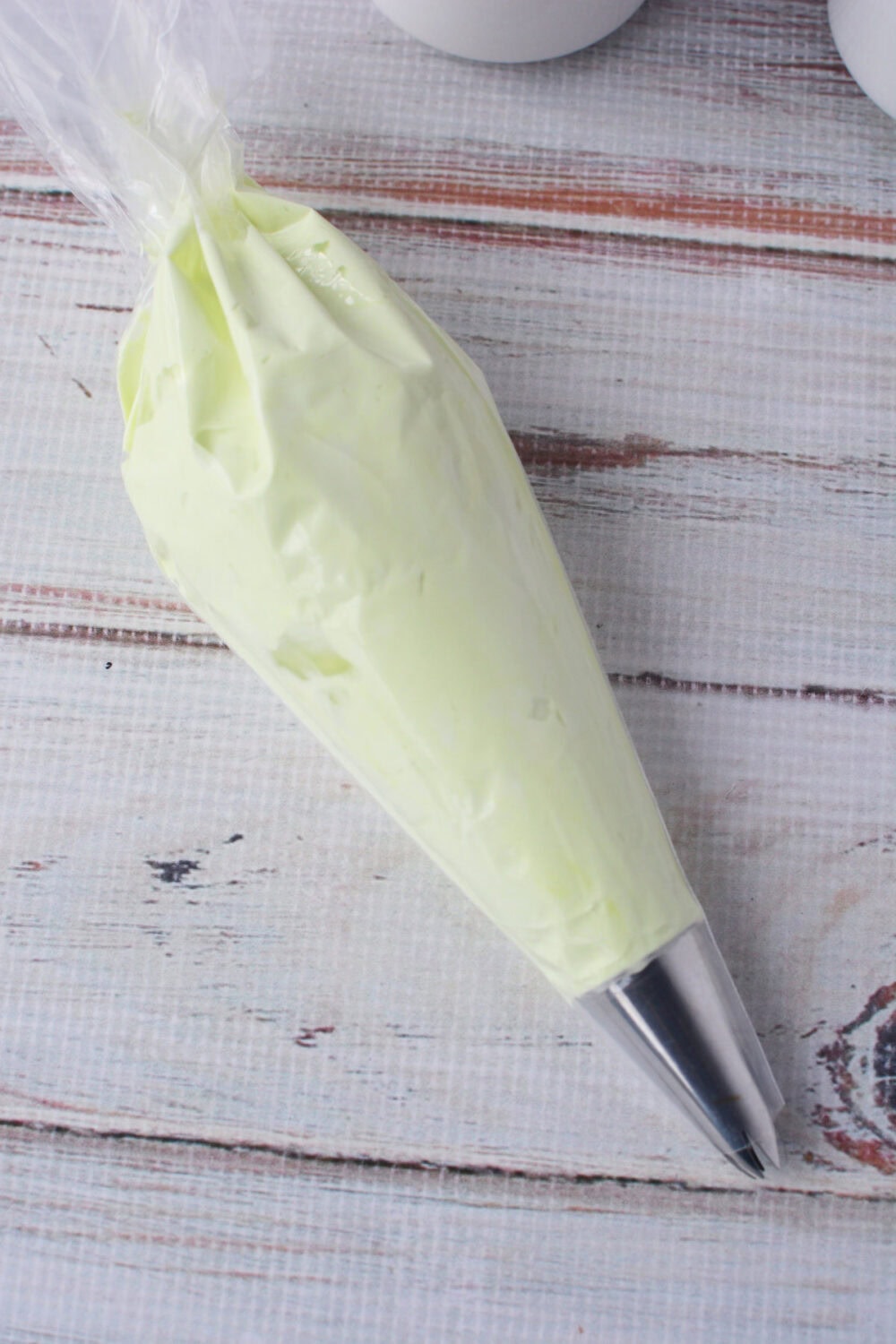 Green whipped topping in a piping bag.