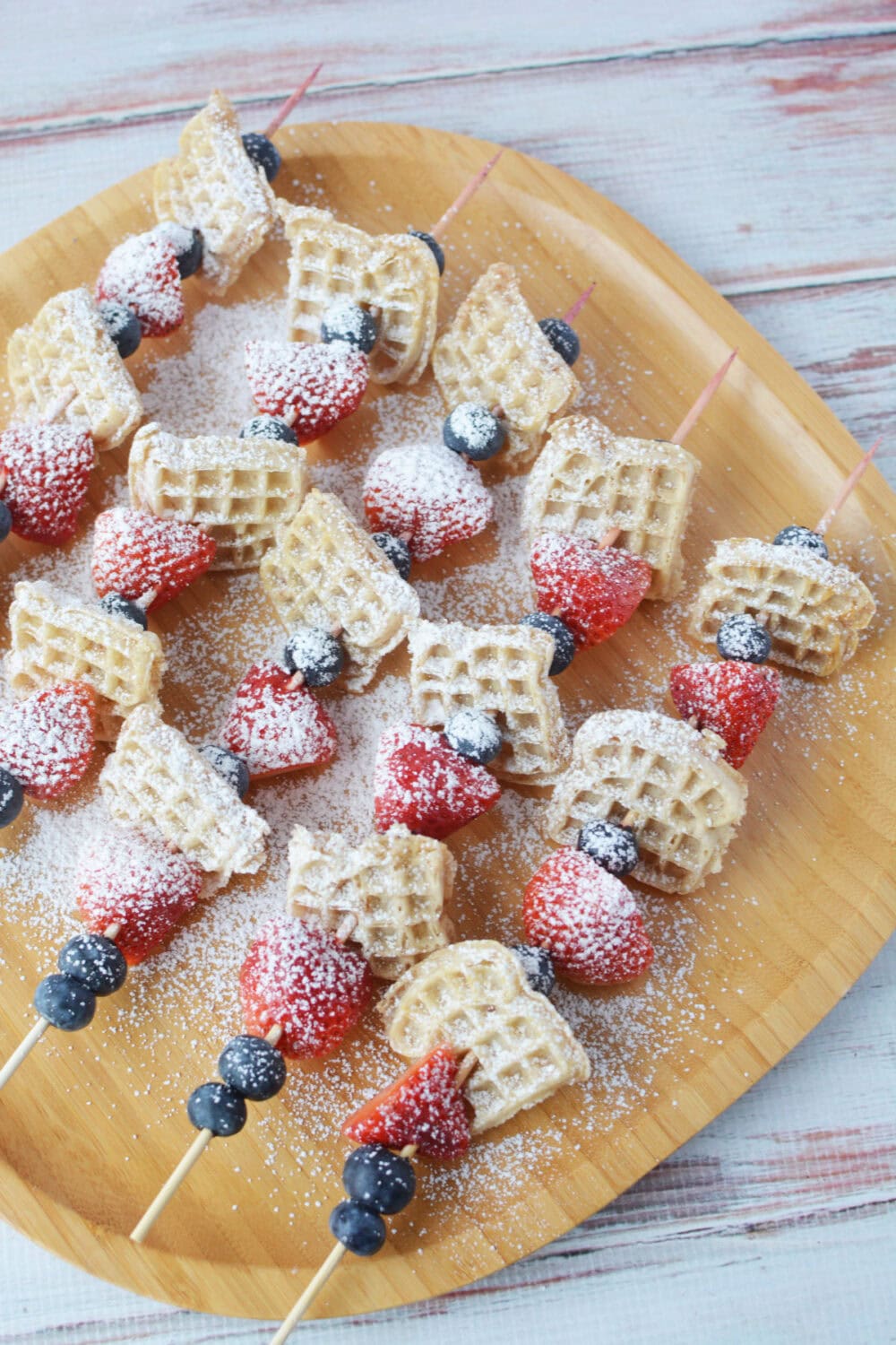 Mini waffle skewers with powdered sugar.