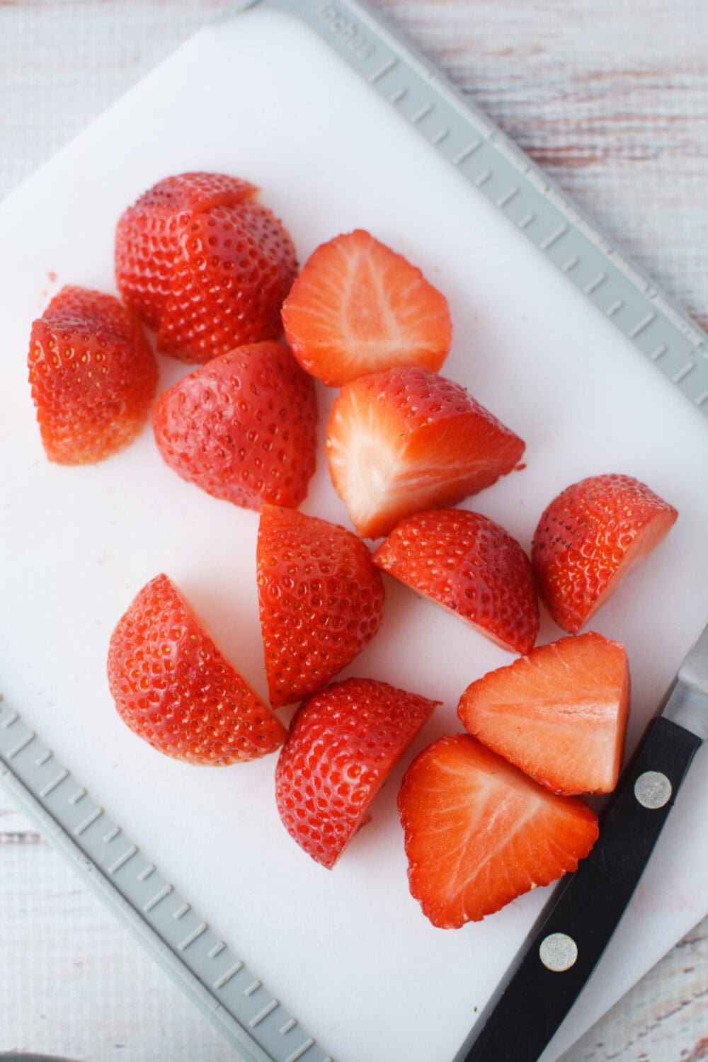 Cut strawberries on a board.