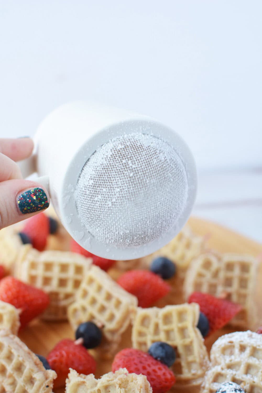 Using a sifting shaker to add powdered sugar.