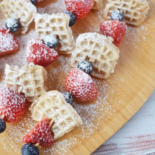 Mini waffle kabobs with strawberries and blueberries.