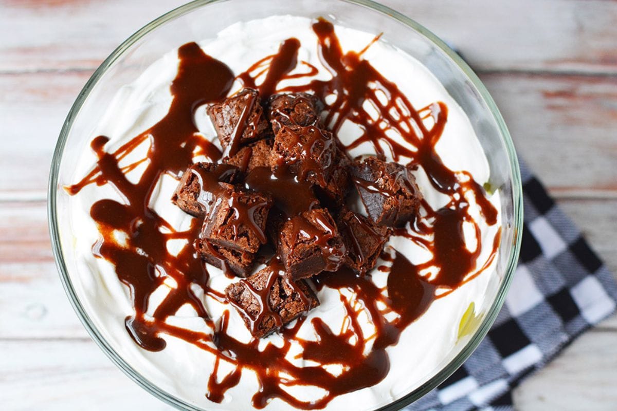 Top of a brownie trifle topped with hot fudge