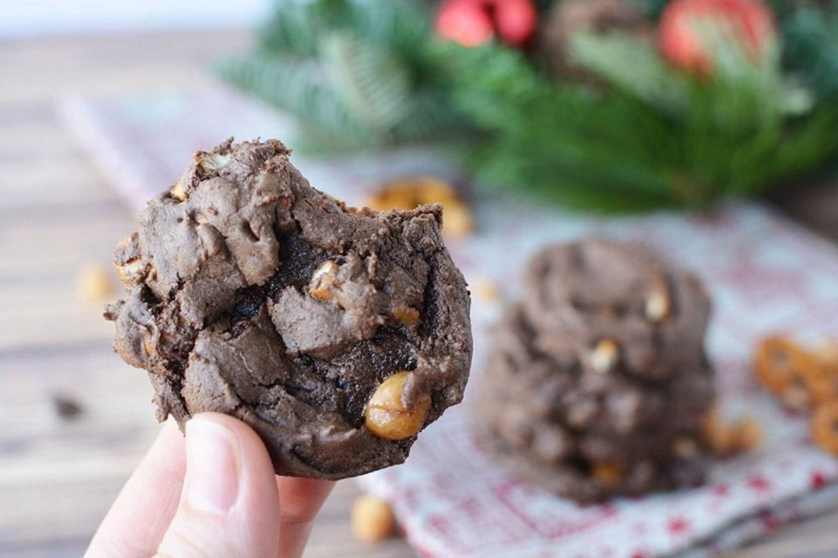 a hand holding a chocolate caramel pretzel cookie