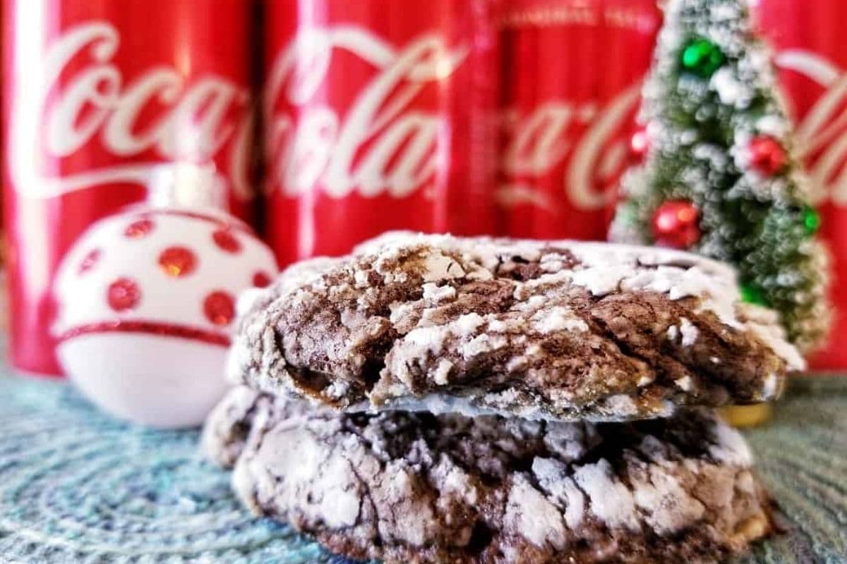 chocolate cookies stacked in front of cans of Coke