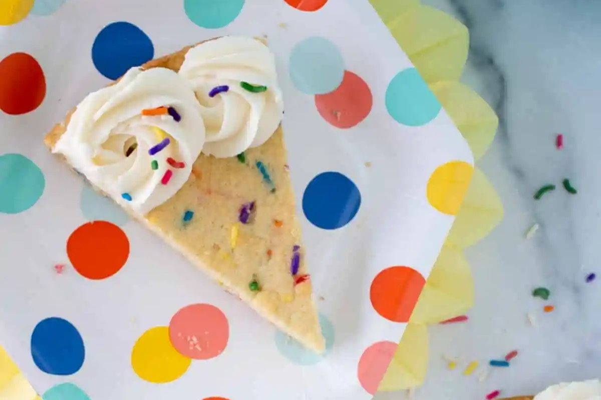 Funfetti cookie cake sliced on a plate