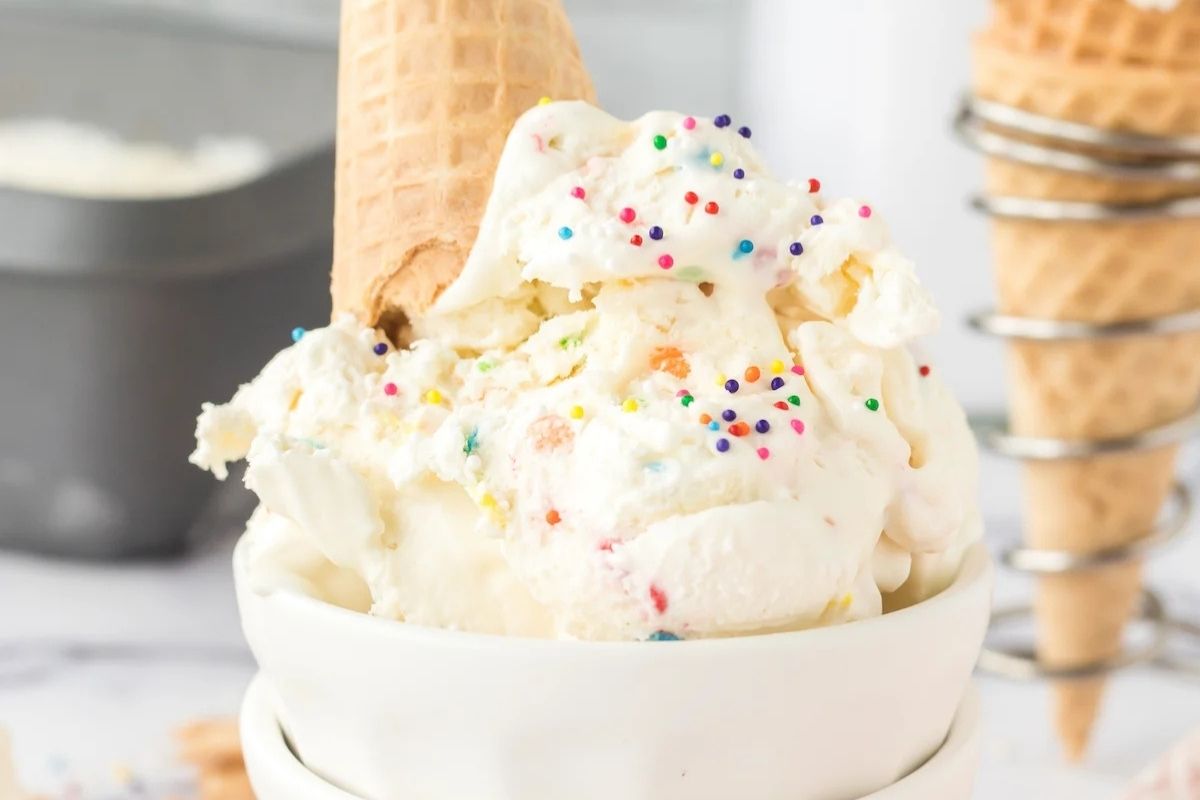 Funfetti ice cream in a bowl with a cone on top