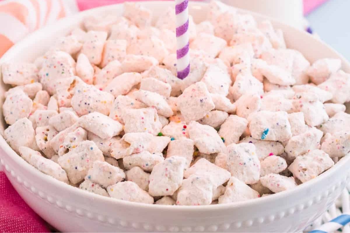 birthday cake puppy chow in a bowl with a candle