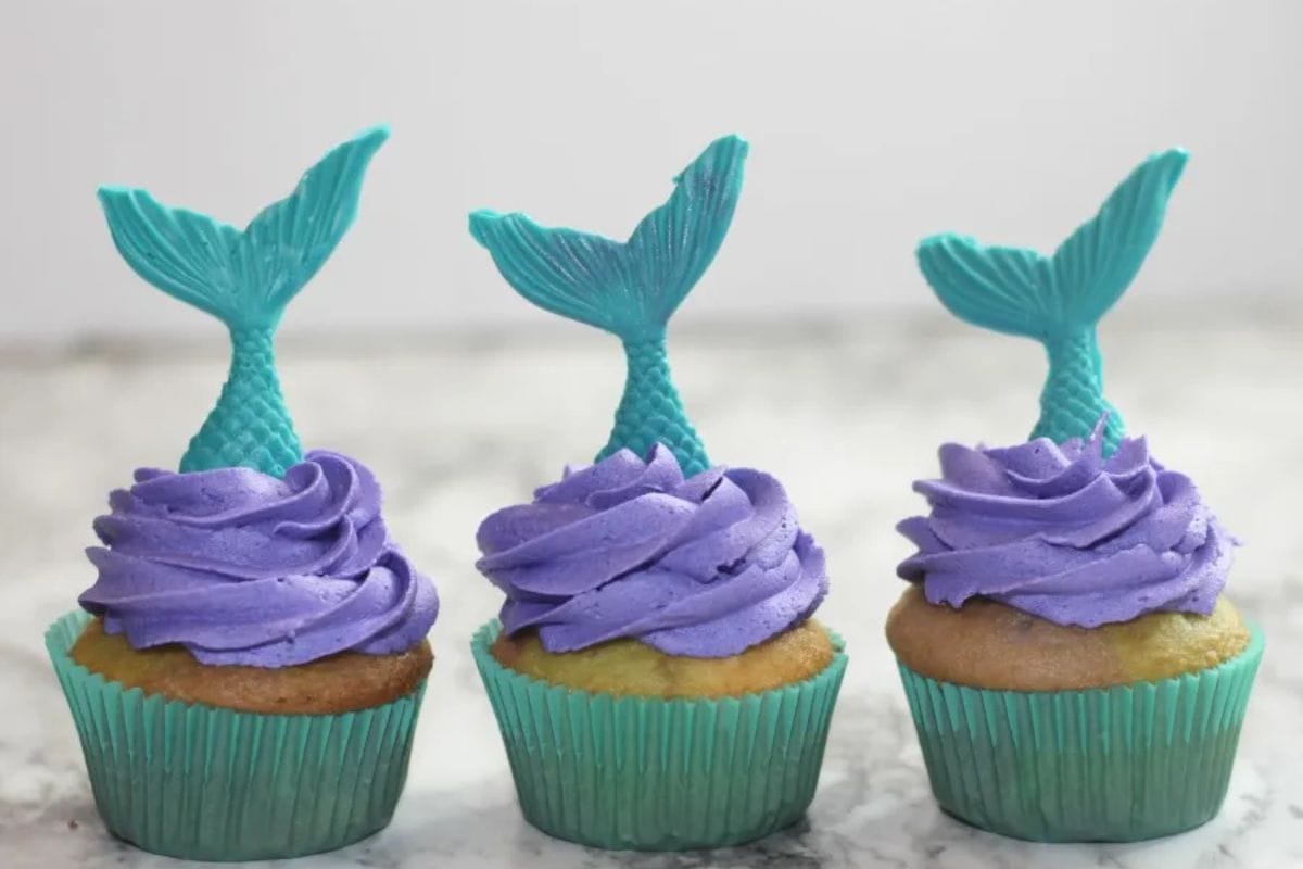 Cupcakes with purple frosting and blue mermaid fins