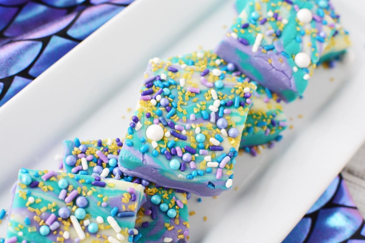 Slices of mermaid fudge stacked on a white tray