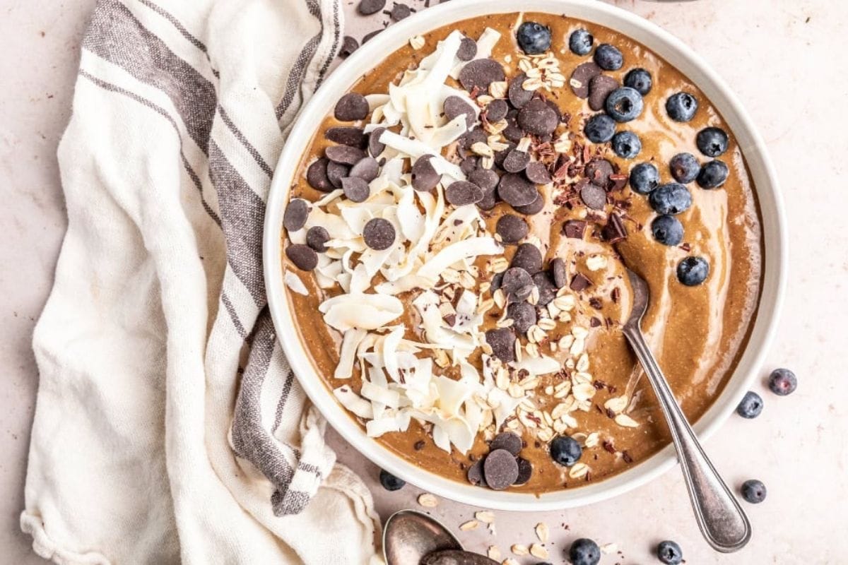 chocolate smoothie bowl with blueberries, chips, and coconut on top