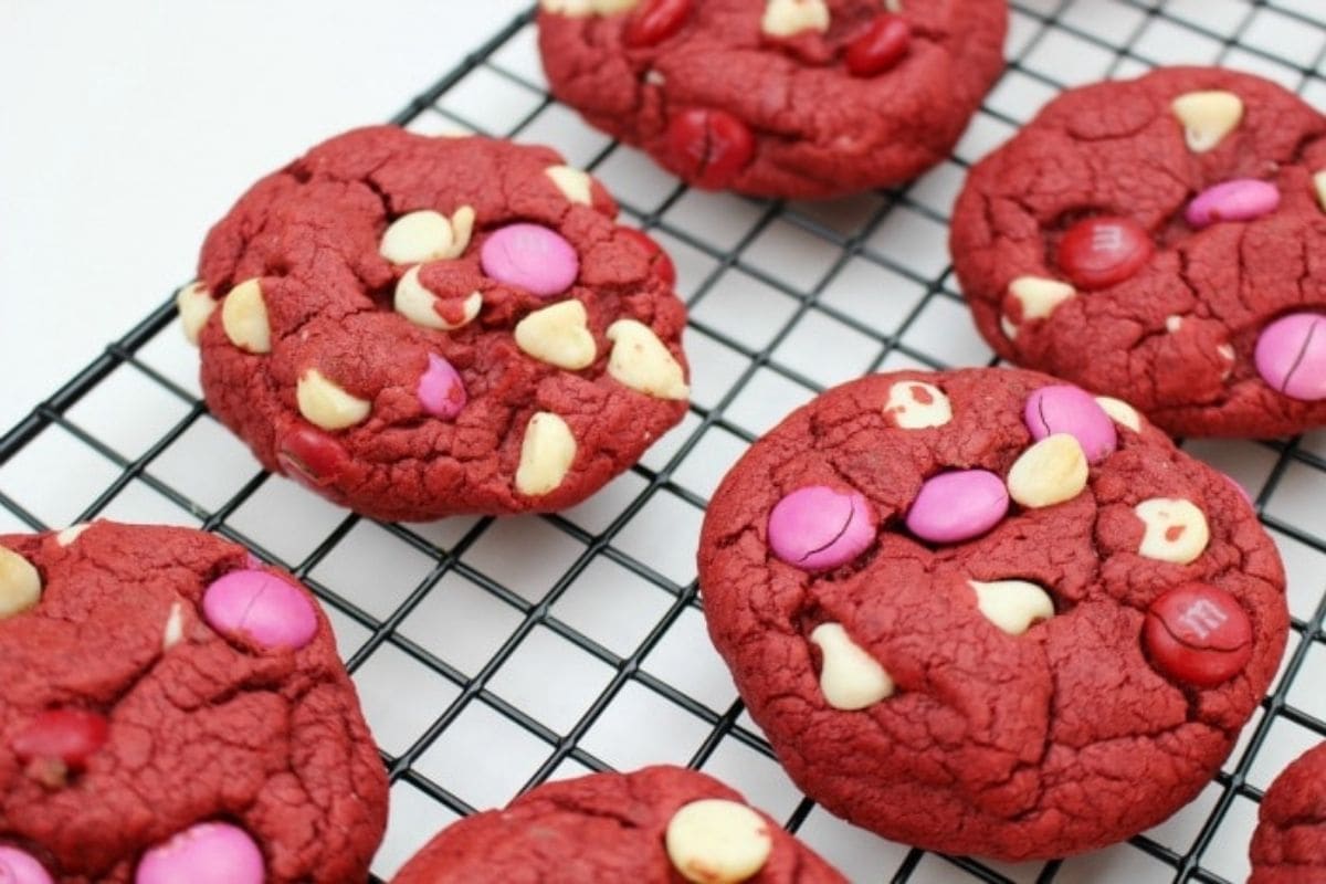 red velvet cookies with white chocolate chips and M&Ms on a wire rack