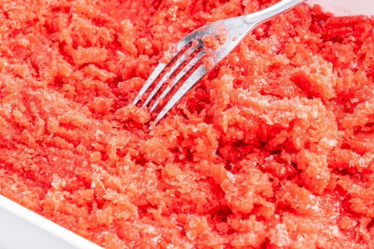 scraping a strawberry granita with a fork