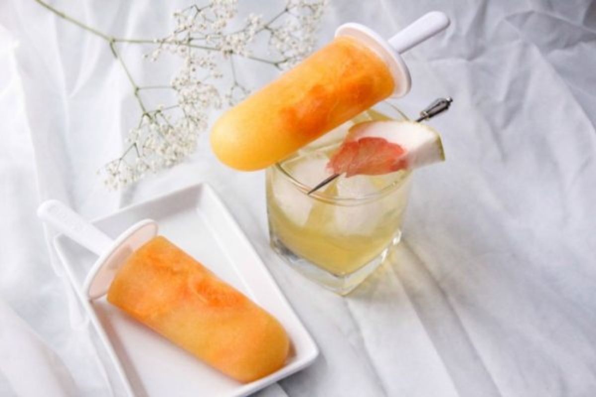 cocktail topped with a tangerine popsicle