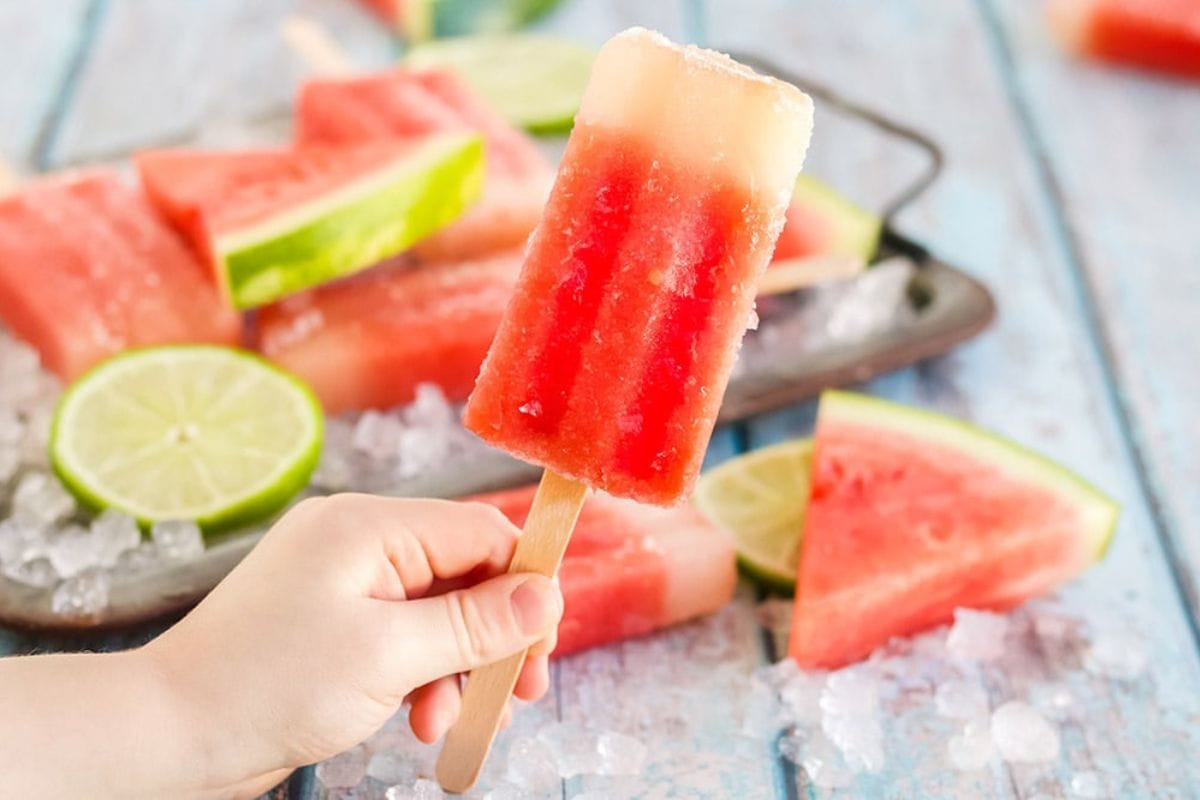 a hand holding a watermelon popsicle
