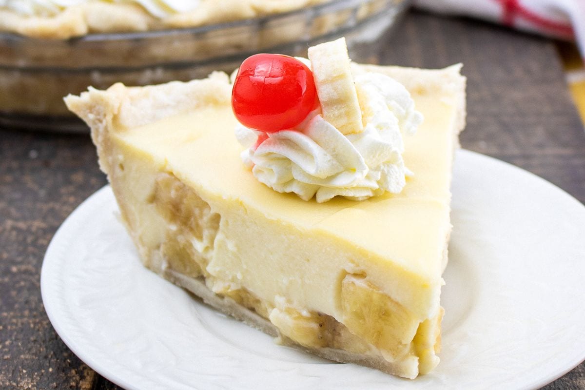 slice of banana cream pie topped with a cherry