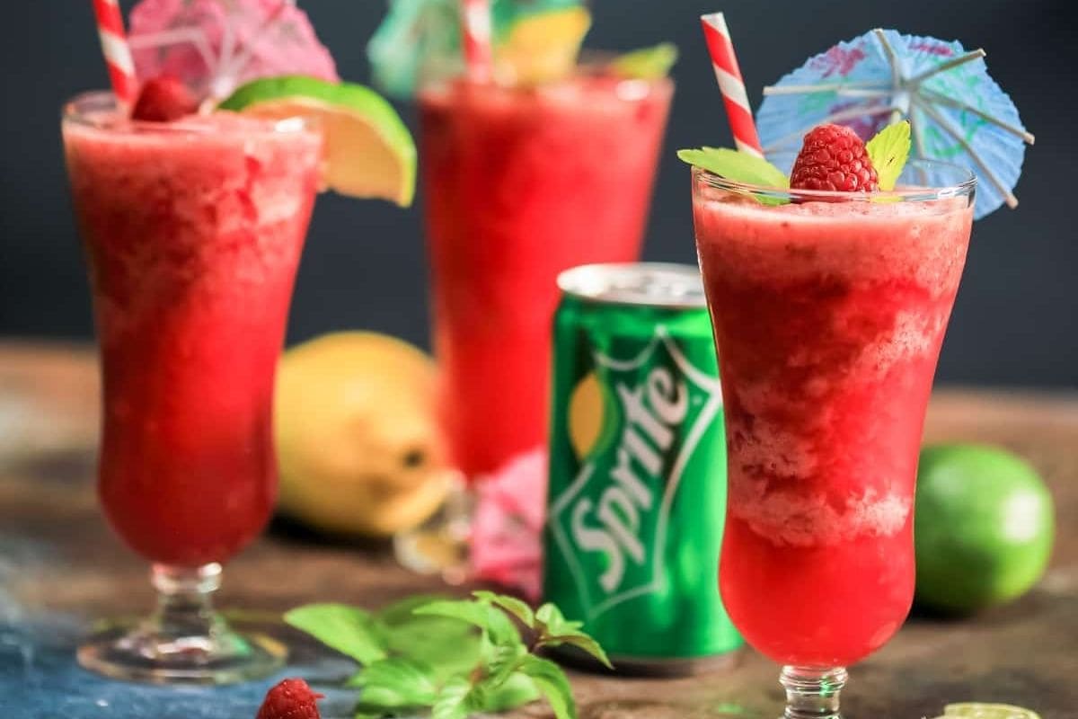 slushy red punch in glasses next to a can of Sprite
