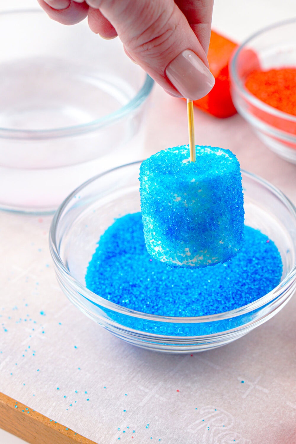 coating a marshmallow in blue sanding sugar