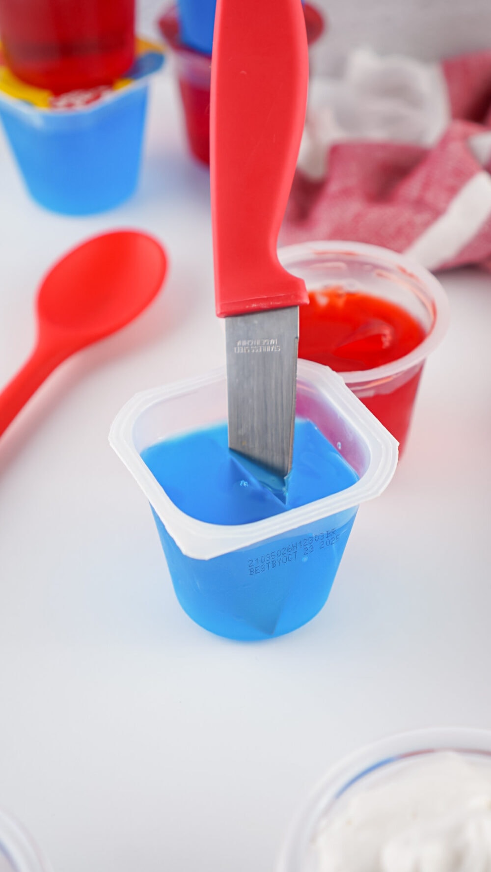 a knife in a blue gelatin cup