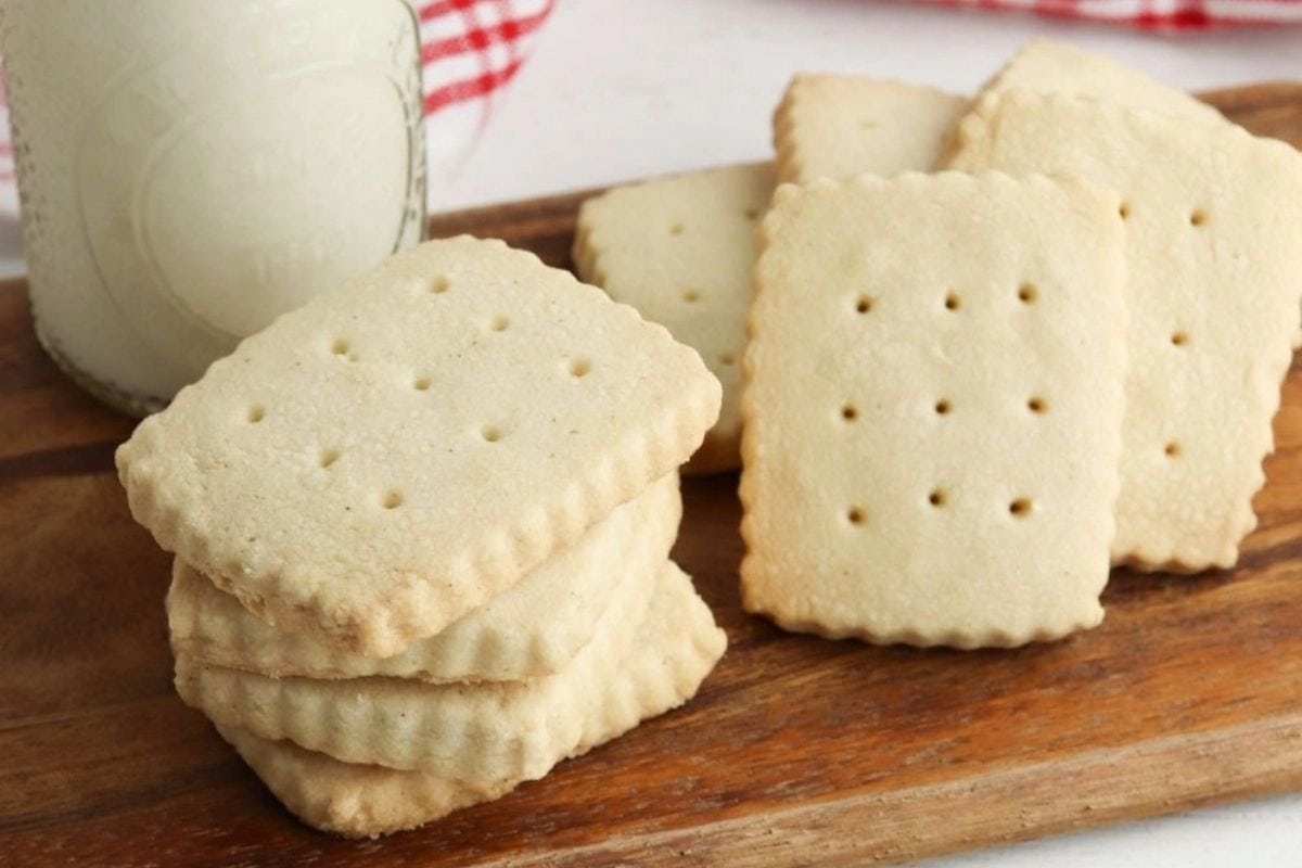 classic shortbread cookies stacked next to a glass of milk