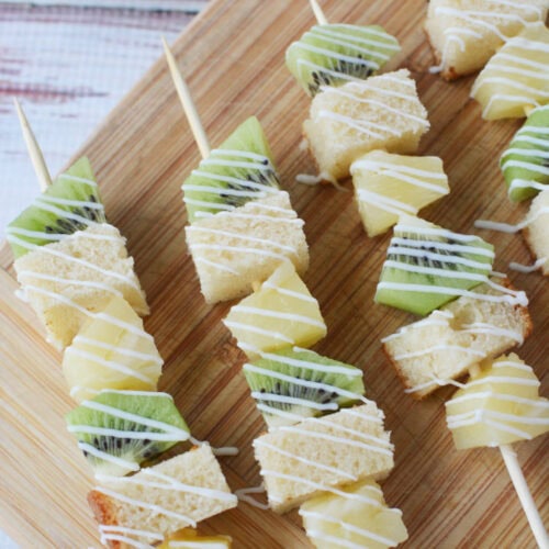 Pineapple, kiwi, and pound cake skewered up on a board