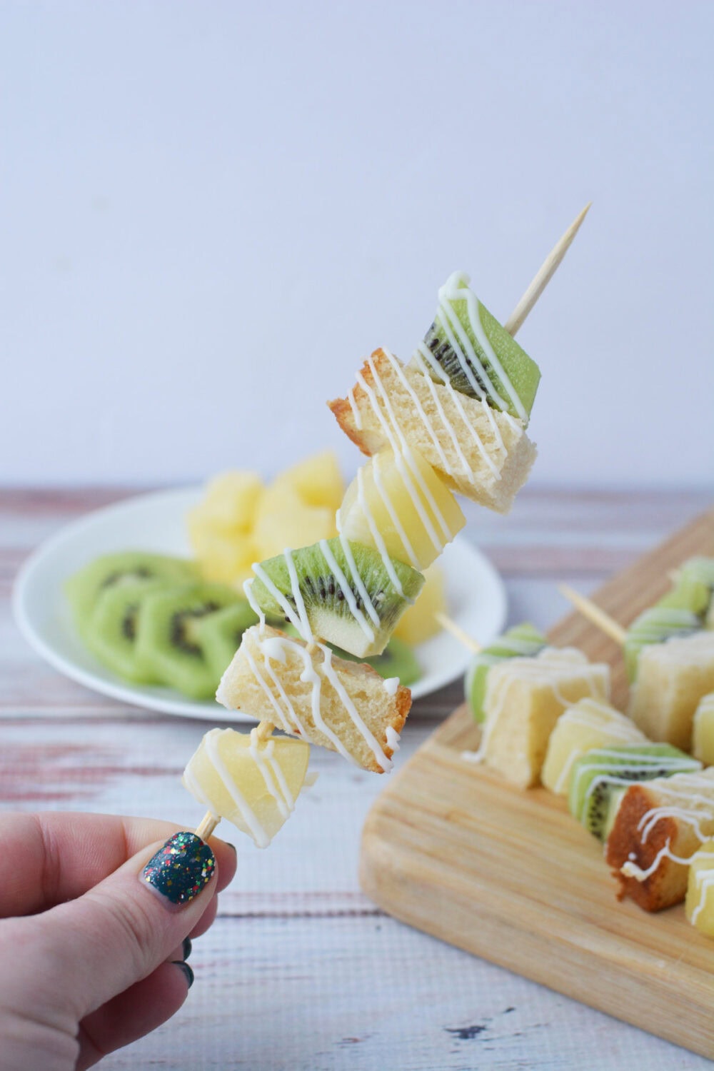 holding a tropical fruit skewer