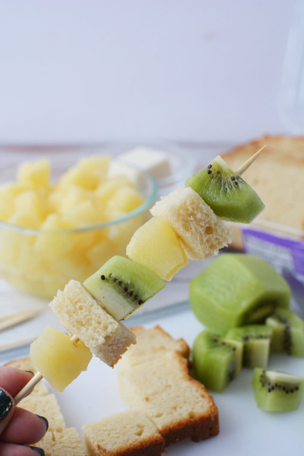 pineapple chunks, pound cake, and kiwi on a skewer