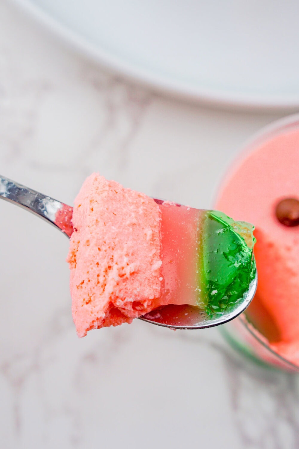 spoon full of layered watermelon gelatin dessert