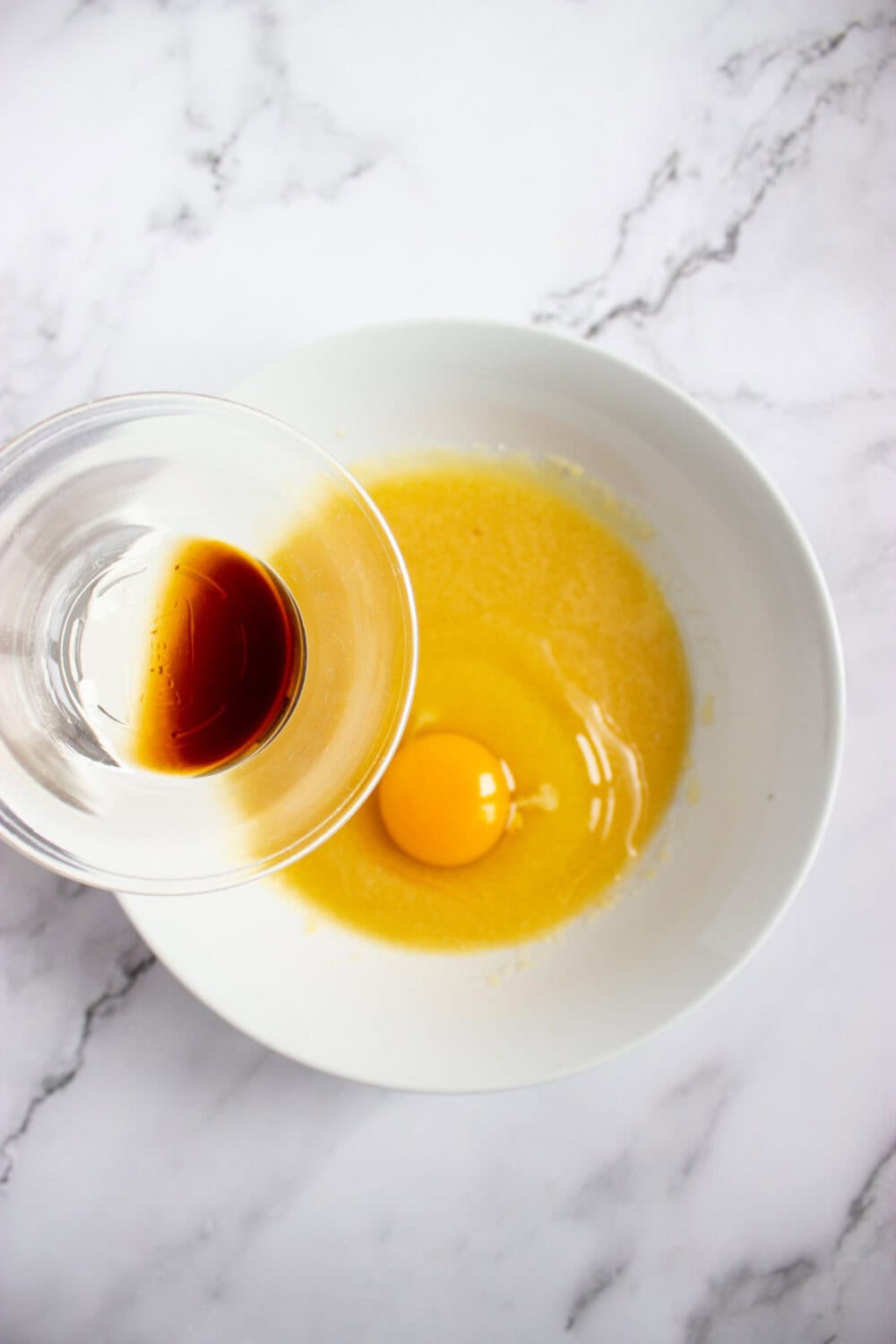 vanilla extract going into bowl with vanilla and butter