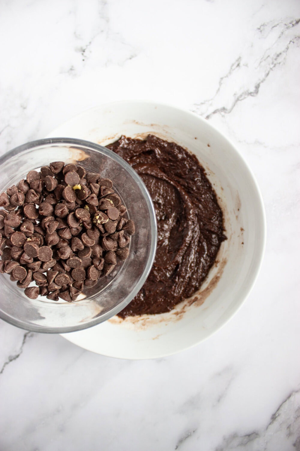 chocolate chips going into brownie dough