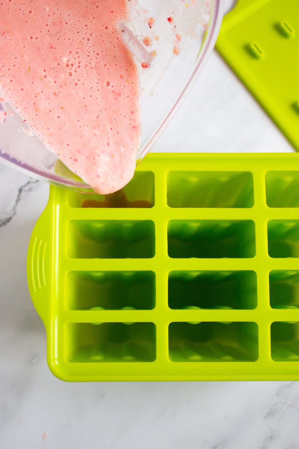 Pouring strawberry mixture into popsicle molds