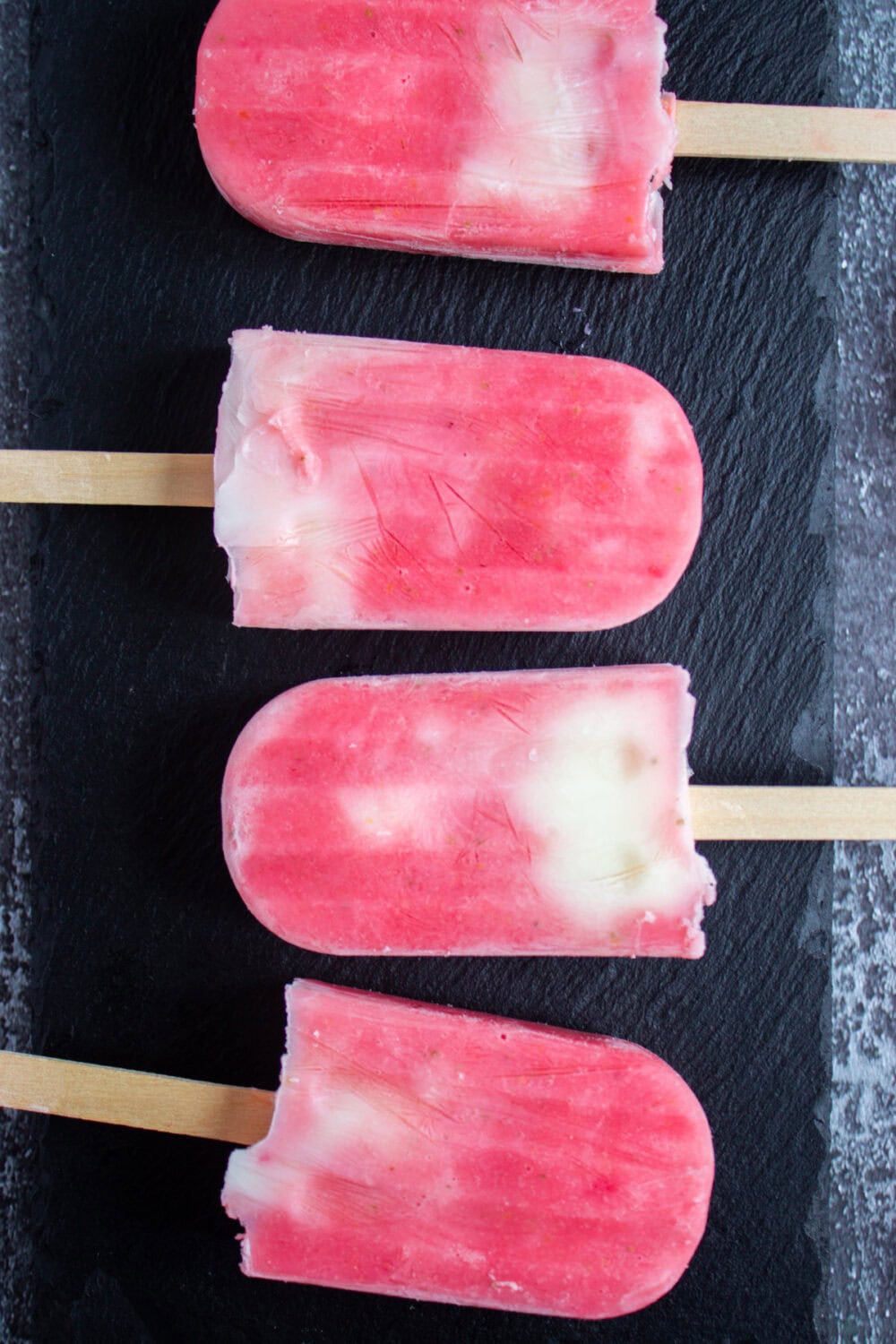 Strawberry yogurt pops lined up on a table