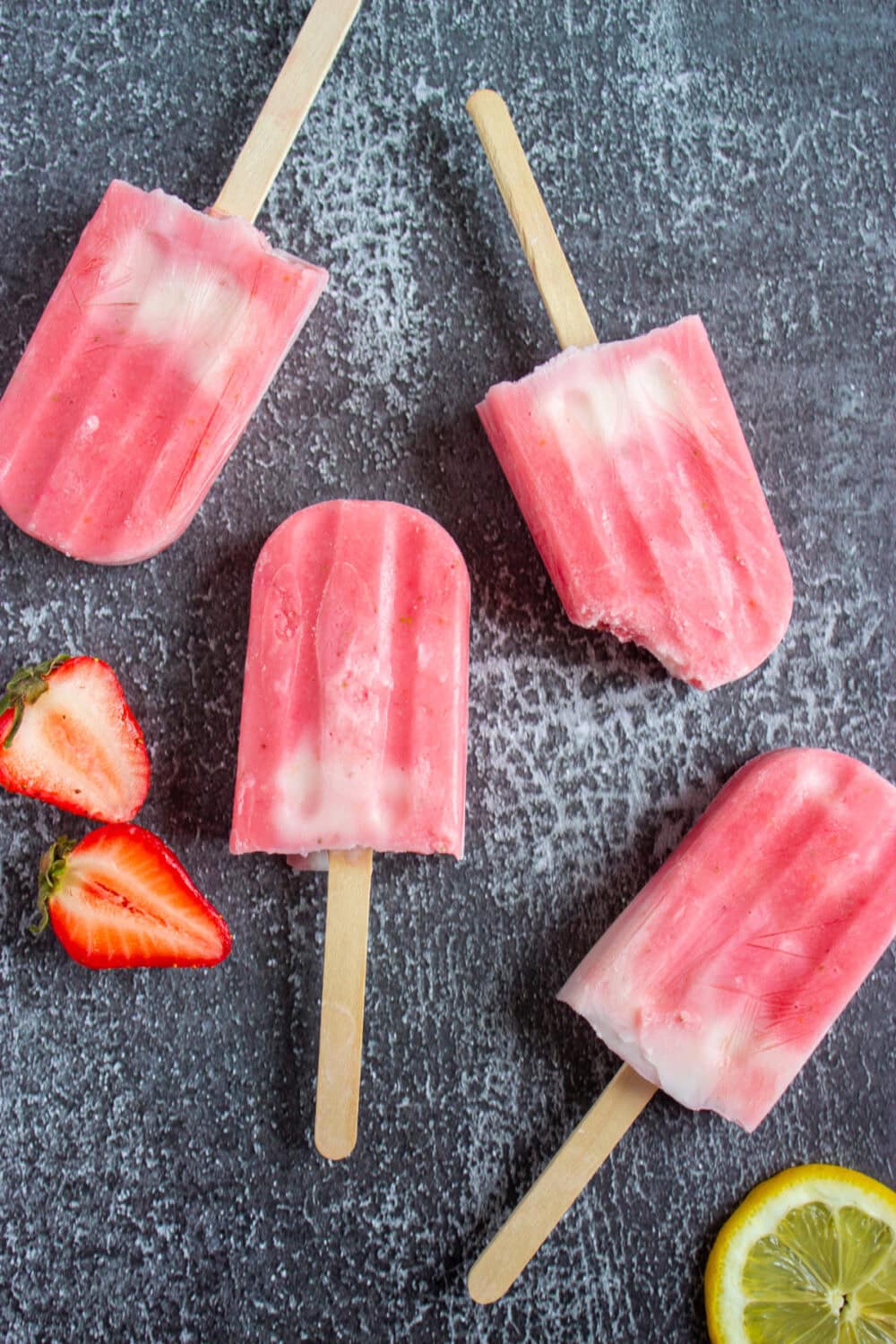 Strawberry yogurt swirl popsicles on a table