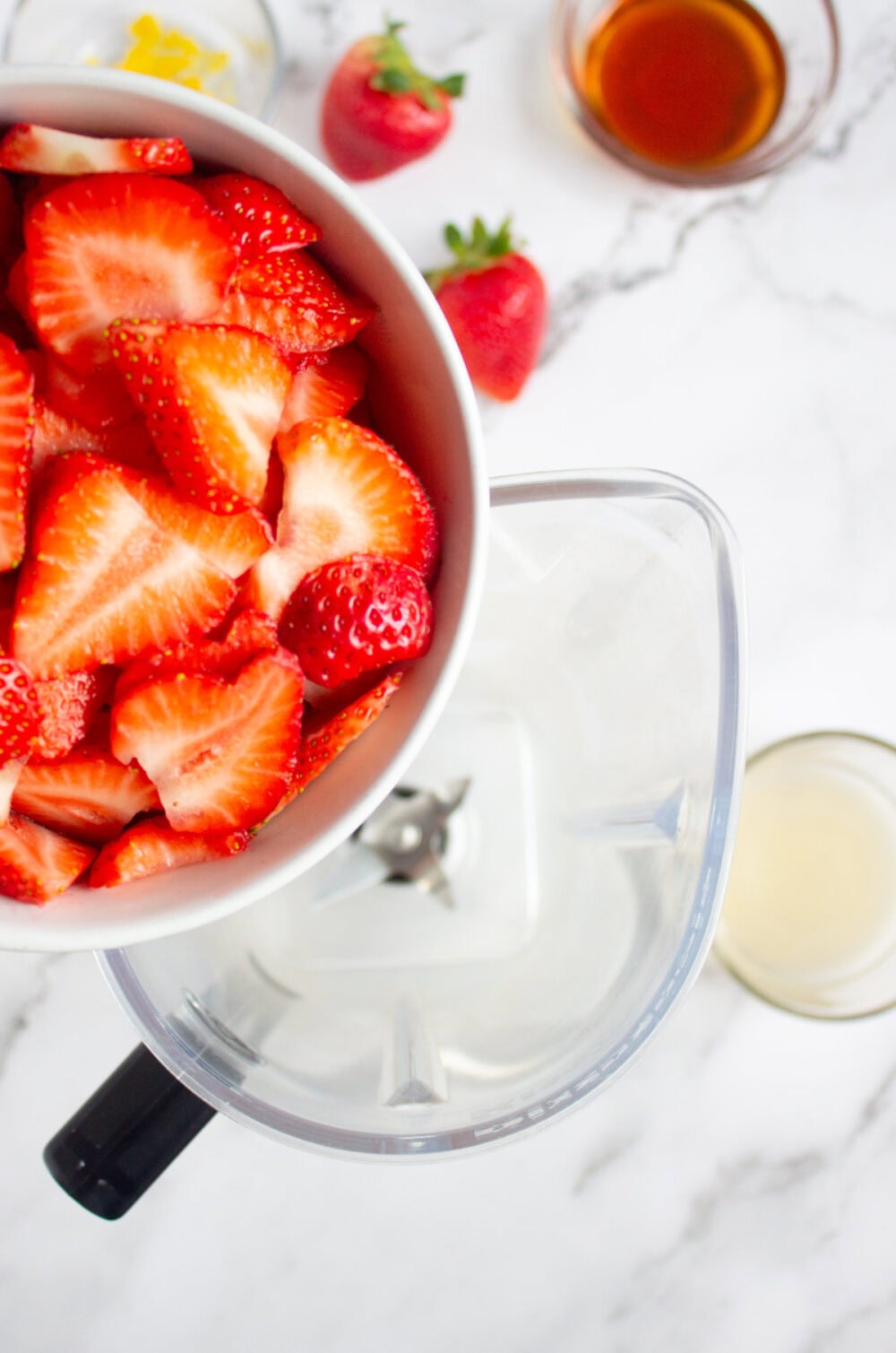 adding strawberries to a blender