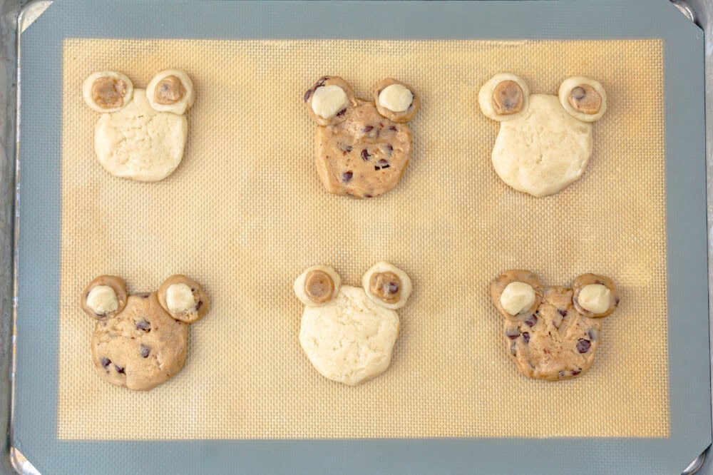 shaping cookie dough into bears on a baking sheet