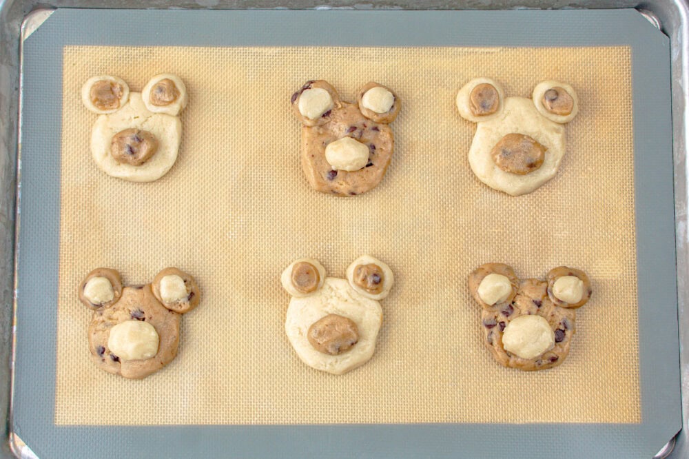 shaping dough into bear faces on a baking sheet